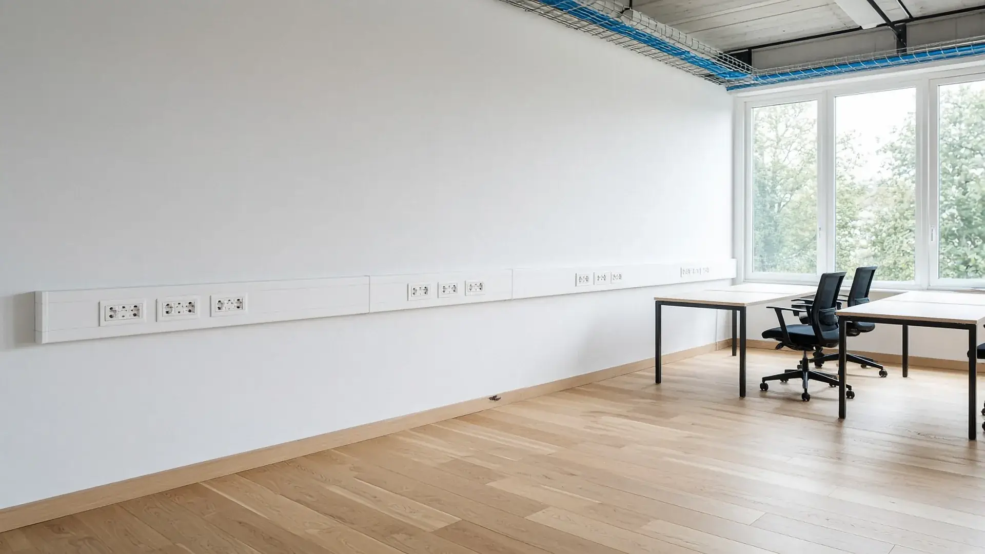 Kantoorruimte met witte wandgoot en wandcontactdozen op bureauhoogte